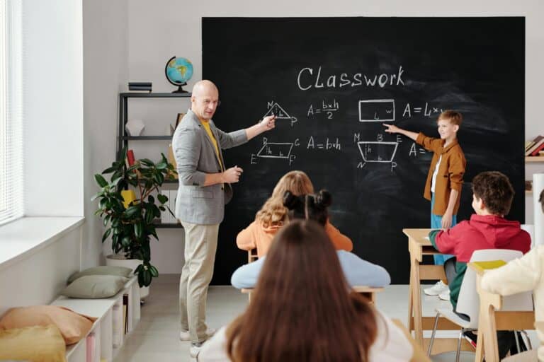 Students actively participating with their teacher during a classwork in the concept of 'top schools in South London'.