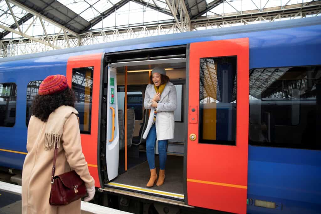 Friends meeting at a tube station in the concept of 'how to use South London's public transport'.