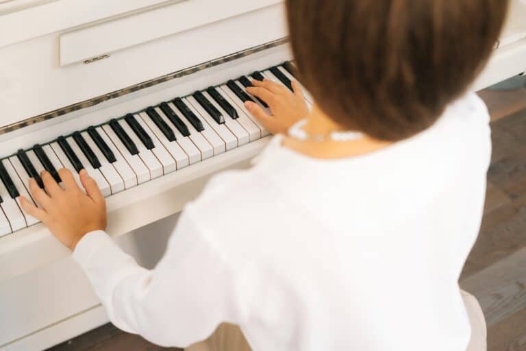 Cropped image of a woman playing a piano in the concept of 'How to Move Pianos and Other Large Fragile Objects When Moving House'.